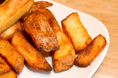 Oven baked potato chips on a white plateの写真素材