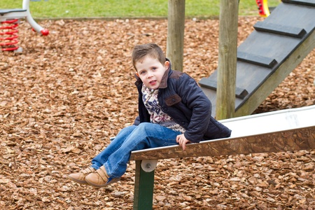 little boy playing a a park on a cold morningの写真素材