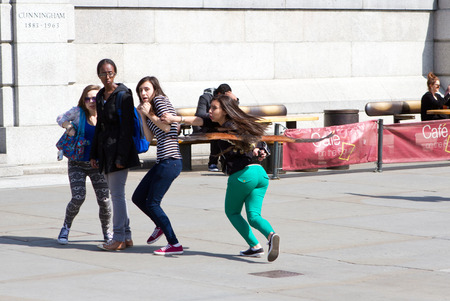 Trafalgar Square, London, UK, 25th April 2013. This pigeon scaring harrier hawk sends a group of teenage girls into a panic のeditorial素材