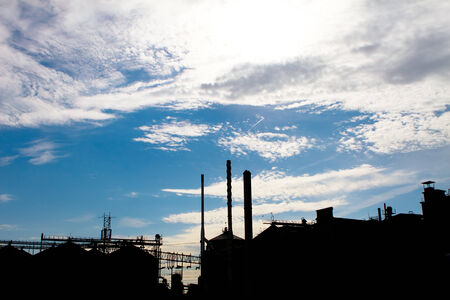 sillohette of a industrial factory against a blue skyの写真素材