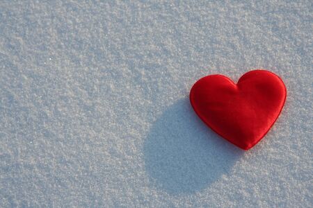 Red silk heart on the snowの写真素材