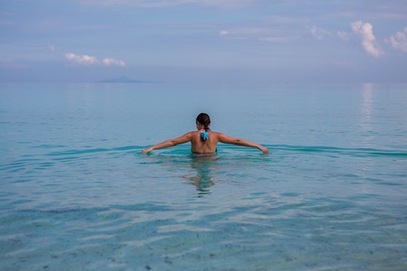 Unrecognizable girl in blue clear sea water.の写真素材
