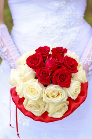 Wedding bouquet with red and white roses in the bride's hands.の写真素材