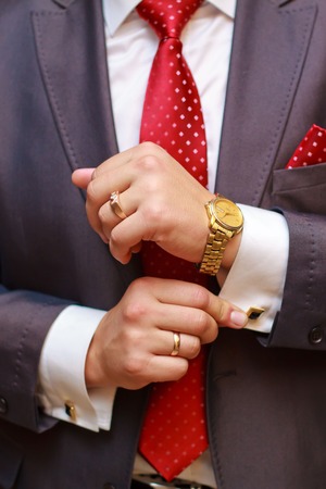 Close up of businessman with red tie and golden watch.の写真素材