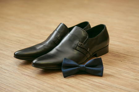 Black bow tie and black man's shoesの写真素材