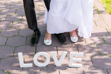 Feet of groom and bride and white love lettersの写真素材