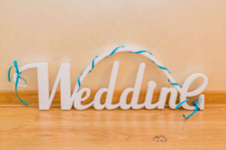 Word wedding, white letters and gold wedding rings.の写真素材
