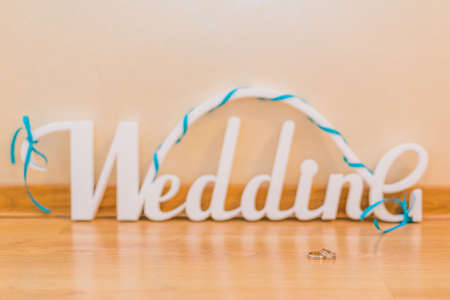 Word wedding, white letters and gold wedding rings.の写真素材