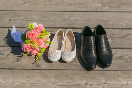 Bride and grooms shoe on the brown wooden floorの写真素材