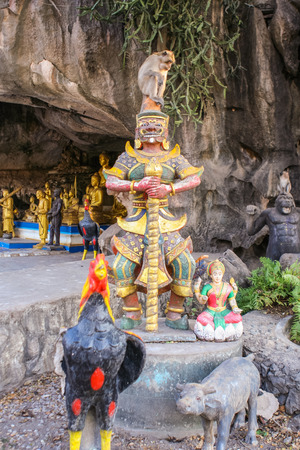Monkey seats on the buddist statue. Thailand.の写真素材
