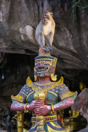 Monkey seats on the buddist statue. Thailand.の写真素材