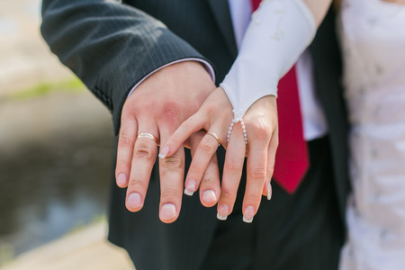 Hands of the bride and groom on the each other.