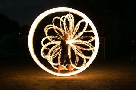 Fire-show man in action in night time.の写真素材