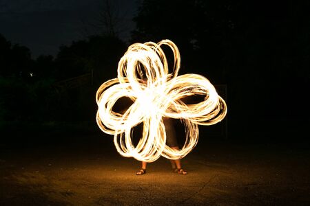 Fire-show man in action in night time.の写真素材