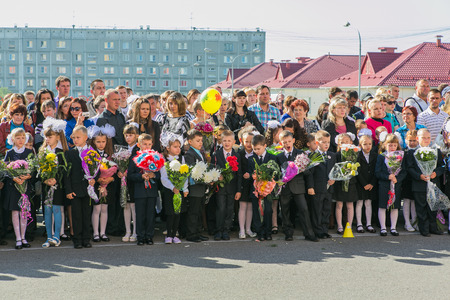 NOVOKUZNETSK, KEMEROVO REGION, RUSSIA - SEP, 1, 2014: Meeting with the first-grade pupils and teacher at schoolyard. The day of knowledge in Russia.のeditorial素材
