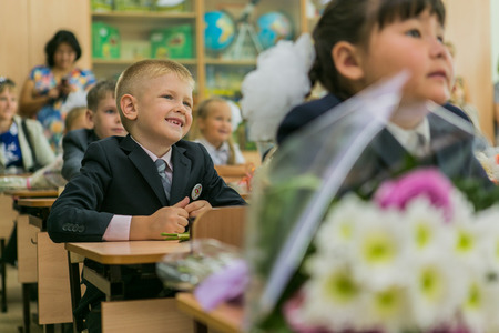 NOVOKUZNETSK, KEMEROVO REGION, RUSSIA - SEP, 1, 2014: First-grade students and teacher are in school classroom at first lesson. The day of knowledge in Russia.のeditorial素材