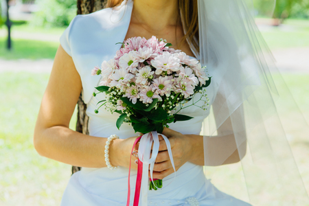 White flowers wedding bouquet in the bride's handsの写真素材