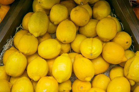 Colorful display of lemons in market. Background.