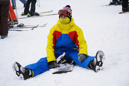 Sheregesh, Mountain Shoria, Kemerovo Region, Russia - 20 February, 2010 :: Young man snowboarder seats on a snowboard in mountainsのeditorial素材