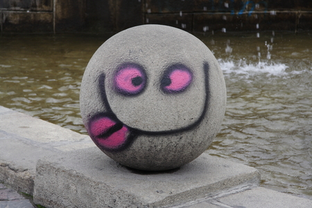 Painted smiley faces on the big round stoune.の写真素材
