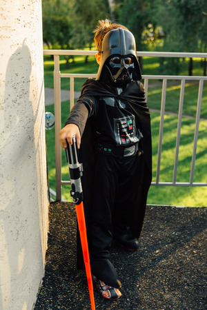 NOVOKUZNETSK, KEMEROVO REGION, RUSSIA - AUGUST 19, 2015 :: Boy in a costume of  Darth Vader with sword from the movie Star Wars in the park.のeditorial素材