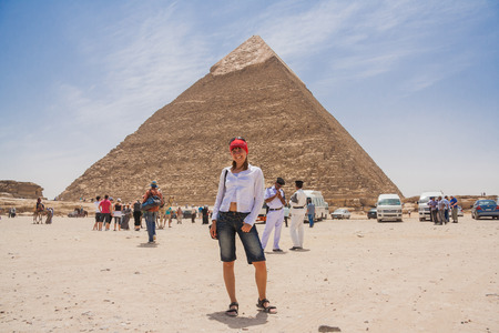 Giza, Cairo, Egypt - June 03, 2010 :: Happy tourist girl and pyramid of Giza in Cairo, Egypt.のeditorial素材