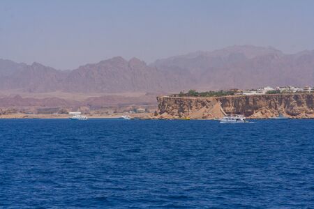 Egyptian beach with mountains and boat at Red sea