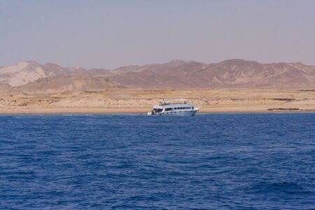 Egyptian beach with mountains and boat at Red seaの写真素材