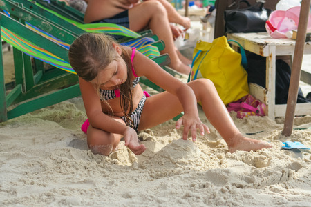 Koh Samed, Rayong, Thailand - December 25, 2014 :: Adorable girl playing with sand on tropical beachのeditorial素材