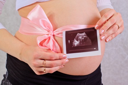 Close up pregnant woman belly with x-ray isolated on the white background.