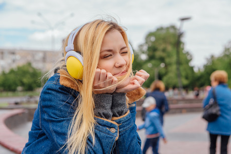 Girl listening to music streaming with headphones. Close up portrait.