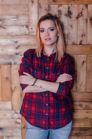 Pretty hipster girl near the wooden wall in loft style roomの写真素材