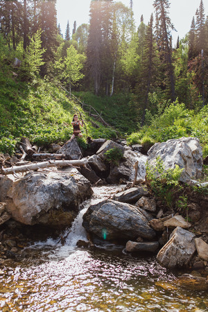 The young beautiful girl amazon aiming a bow while hunting in the forest, mythical character, a fairy tale, the legendの写真素材