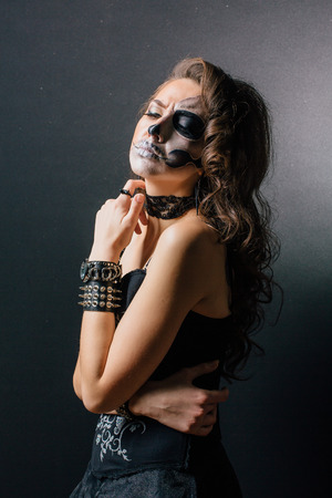 Young woman in black with half face skull make-up.の写真素材
