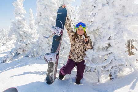 Portrait of young smiling woman with snowboardの写真素材