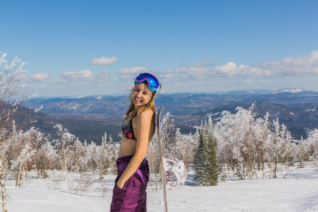Happy girl undressed outside standing with a snowboardの写真素材