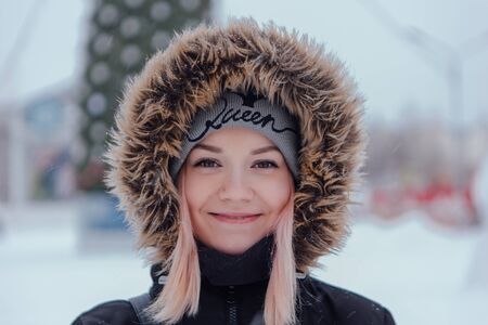 Winter fashion. Portrait of a beautiful young woman in warm clothes outdoor near Christmas tree