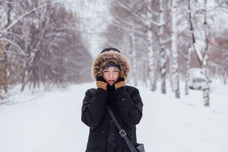 Winter fashion. Portrait of a beautiful young woman in warm clothes outdoor.の写真素材