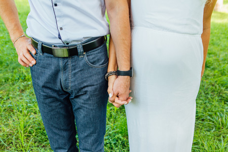 Close up holding hands of a man and a woman outdoorsの写真素材