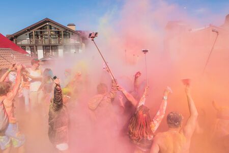 Sheregesh, Kemerovo region, Russia - April 16, 2016: Grelka Fest is a sports and entertainment activity for ski and snowboard riders in bikini. A group of a young people throwing colorful holi powder.のeditorial素材
