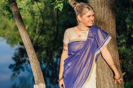 Beautiful european woman in traditional indian sari near the lakeの写真素材