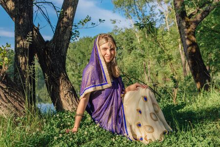Beautiful european woman in traditional indian sari near the lake