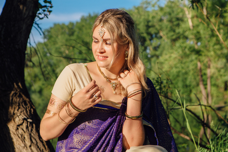 Beautiful european woman in traditional indian sari near the lakeの写真素材