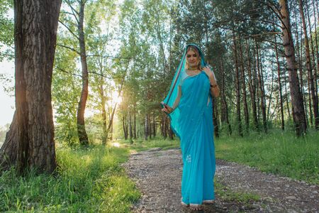 Beautiful european woman in traditional indian sari in the forestの写真素材