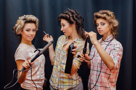 Portrait of three young girls making hairdress to each otherの写真素材