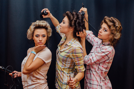 Portrait of three young girls making hairdress to each otherの写真素材