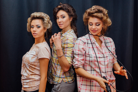 Portrait of three young girls making hairdress to each otherの写真素材