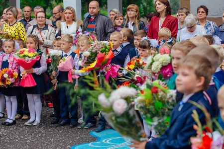 NOVOKUZNETSK, KEMEROVO REGION, RUSSIA - SEP, 1, 2017: Meeting with the first-grade pupils and teacher at schoolyard. The day of knowledge in Russia.のeditorial素材