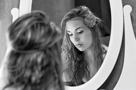 Beautiful sexy woman in a bra near the mirror in the bedroomの写真素材