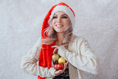 Happy excited young woman in santa claus hat with christmas decorationsの写真素材